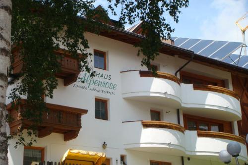 a building with a sign on the side of it at Pension Alpenrose in Serfaus
