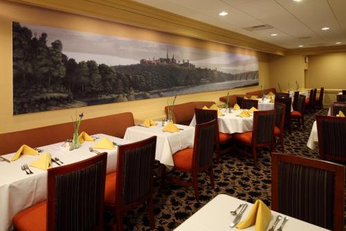 a restaurant with tables and chairs and a painting on the wall at Georgetown University Hotel and Conference Center in Washington, D.C.