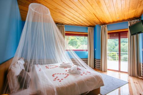 a bedroom with a bed with a mosquito net at Quinta do Rio Gerês in Bouro