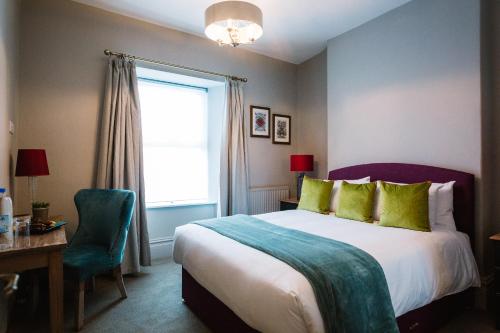 a bedroom with a bed and a desk and a window at Bampton Townhouse in Bampton