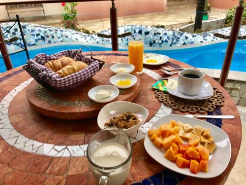 a table with breakfast food and drinks on a table near a pool at Eco Hotel Katarma in Puerto Baquerizo Moreno