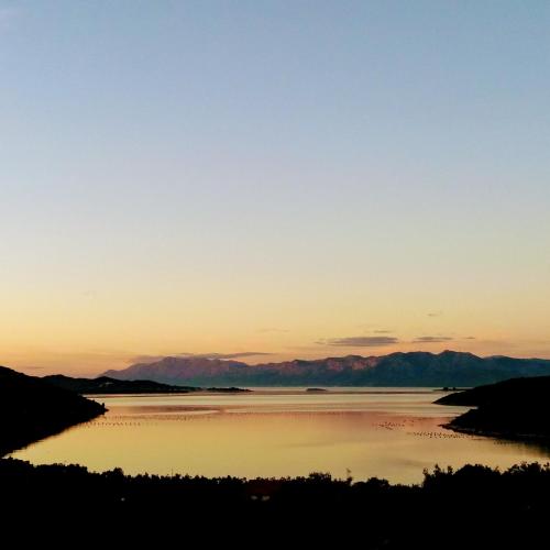 a sunset over a body of water with mountains in the background at Bellavista Peljesac Peninsula in Dubrava