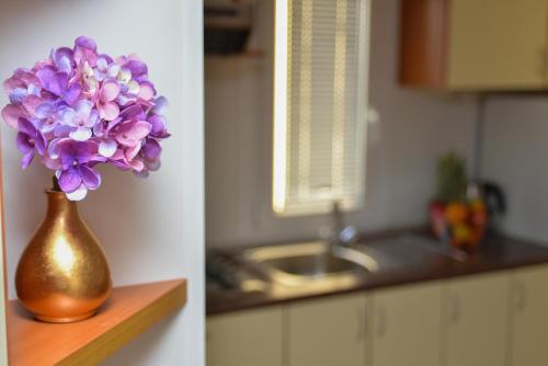 eine Vase lila Blumen, die auf einer Theke in einer Küche liegt in der Unterkunft Lavender Mobile Houses in Pakoštane