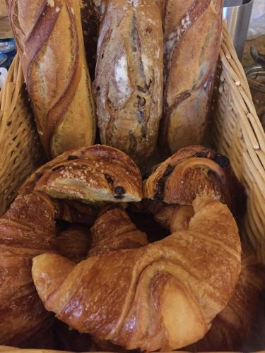 un panier rempli de différents types de pain dans l'établissement Le Chevrefeuille chambres d'hotes et gîtes de charme, à Meyrals