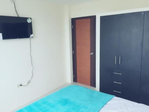 1 dormitorio con 1 cama, TV y armario en Casa Estrella Santa Rosa, en Santa Rosa