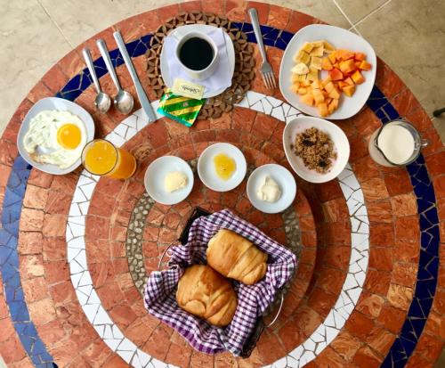 a plate of food with eggs and croissants on a table at Eco Hotel Katarma in Puerto Baquerizo Moreno