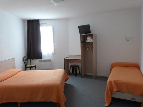 a hotel room with two beds and a desk at Relax Hotel in Maillat