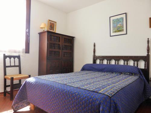 sypialnia z niebieskim łóżkiem i krzesłem w obiekcie 4VSE-COB279 Appartement proche plage avec parking privé w mieście Collioure