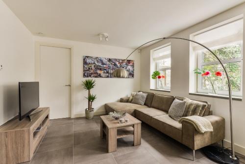 a living room with a couch and a tv at Luxury Family Residence Schinkeldijkje in Aalsmeer