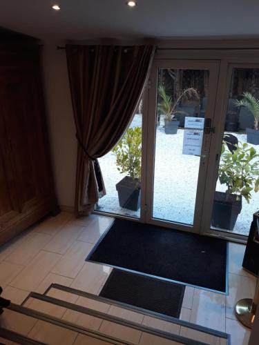 a room with a sliding glass door with plants outside at Le moulin in Pornic