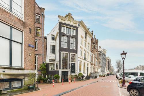 a street with buildings and cars parked on the street at Classy Room 17th C Canalhouse in Amsterdam