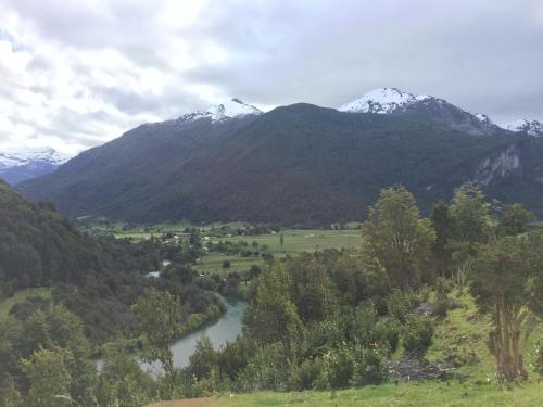 a river with snow capped mountains in the background at Turismo Rural Los Alpes in Futaleufú