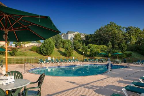 una piscina con una mesa y una sombrilla verde en Palace View Resort by Spinnaker, en Branson