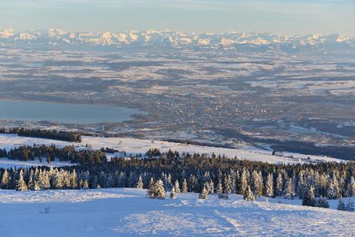 an aerial view of a snow covered mountain with trees at La Clé des Champs in Les Fourgs