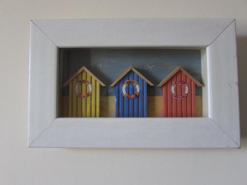 a framed picture of four colorful beach huts at Hull Trinity Backpackers in Hull