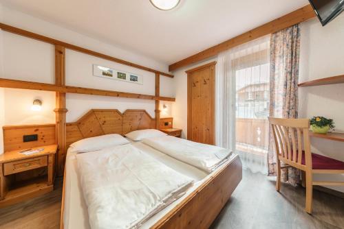 サン・カッシアーノにあるPension Garni Plangのベッドルーム1室(ベッド1台、デスク、窓付)