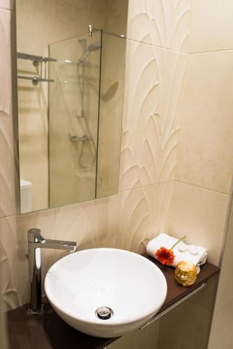 a bathroom with a white sink and a shower at Cuatro Caminos Rooms in Torrelavega