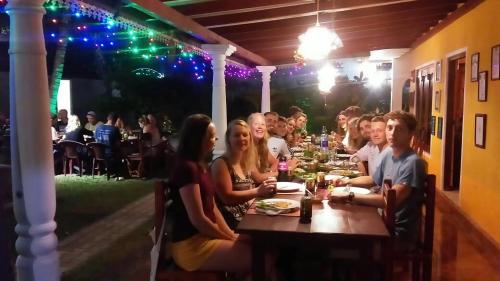 a group of people sitting at a table at a restaurant at Plantation Surf Inn & Restaurant - Midigama in Midigama