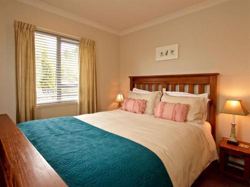 a bedroom with a large bed and a window at Kotiri Chalet in Ohakune