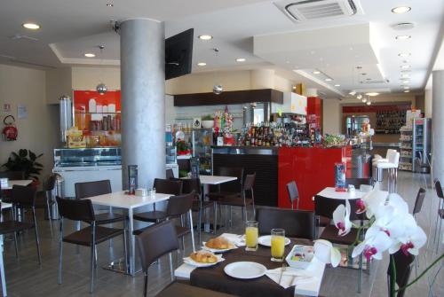 a restaurant with tables and chairs and a bar at Kiara Residence in Giulianova