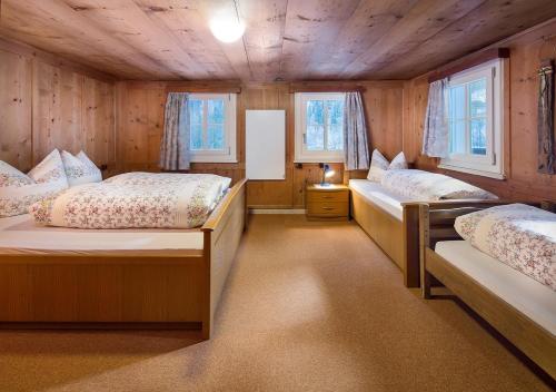 シュルンスにあるElke´s Sennhütteのベッド2台 ウッドウォールと窓が備わる客室です。