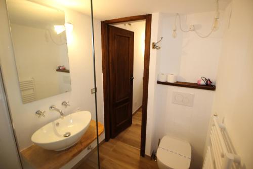 a bathroom with a sink and a toilet and a mirror at Appartamento Melograno in San Bartolomeo al Mare