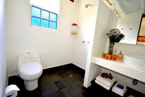 a white bathroom with a toilet and a sink at Hotel Casa Terra in Villa de Leyva
