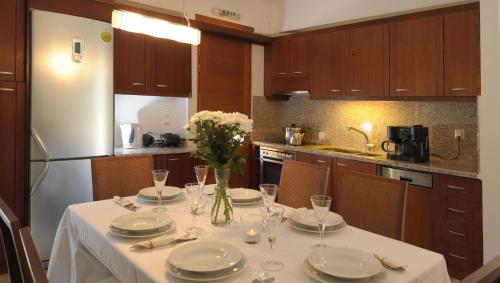 una cocina con una mesa con platos y un jarrón de flores en Manolioudis Villas, en Balíon