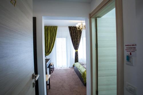 a room with a bedroom with a bed and a window at Hotel-Restaurant Ayan Piatra Neamt in Piatra Neamţ