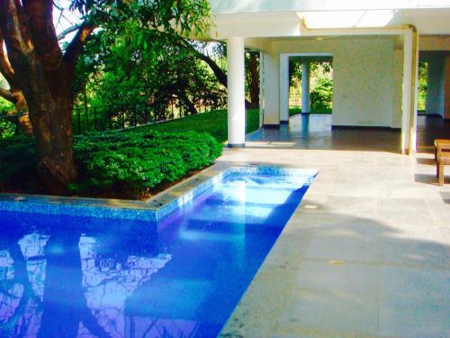 a swimming pool in the middle of a yard at Luxurious 2BHK for Ultimate Holiday Experience in Goa - 2 in Candolim