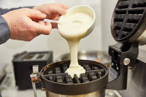 a person is preparing food in a machine at Die Reichsstadt - Hotel Spa und Restaurant in Gengenbach