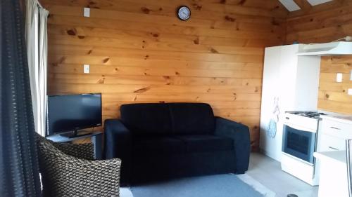 a living room with a chair and a television at Whangarei Holiday Houses in Whangarei