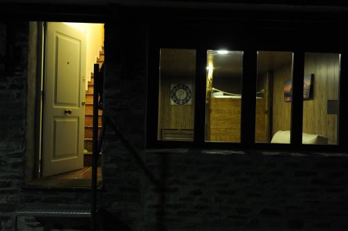 Habitación con ventana, cama y puerta en Estudio y Casa Los Copos, en Sierra Nevada