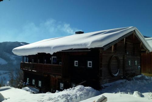 a log cabin with snow on top of it at Almhütte Brandgut in Mühlbach am Hochkönig