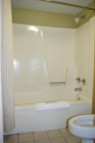 a bathroom with a white tub and a toilet at Americas Best Value Inn St. Louis Downtown in Saint Louis