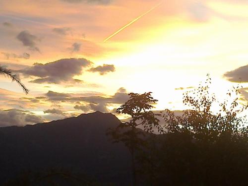 a sunset with a silhouette of a mountain in the sky at Garni Reider in Meltina