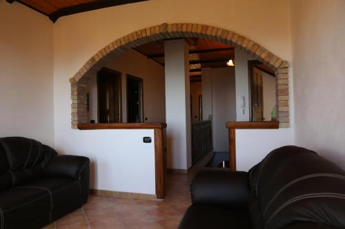 a living room with a couch and an archway at Agriturismo Pirara in Gerocarne