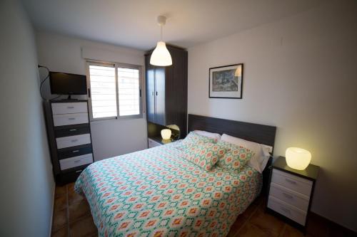 um quarto com uma cama, uma televisão e uma janela em Apartamento Voramar em Daimuz