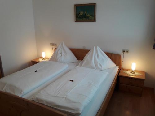 a bed with two white pillows and two lamps at Ferienwohnung Kupfer in Göstling an der Ybbs