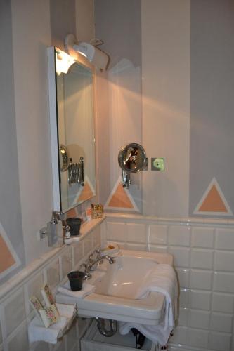 a white bathroom with a sink and a mirror at Casa Cuniolo Guest House in Tortona
