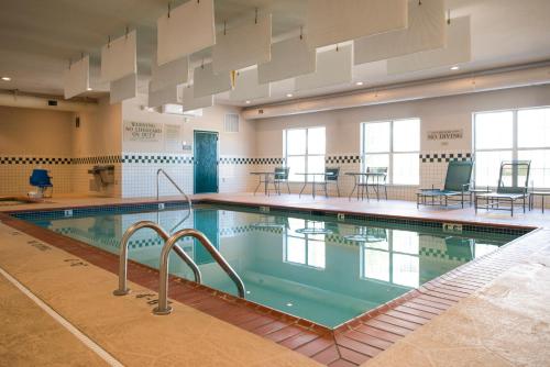 a large swimming pool in a room with tables and chairs at Country Inn & Suites by Radisson, Effingham, IL in Effingham