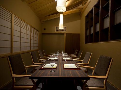 a long wooden table in a room with chairs at Saka Hotel Kyoto in Kyoto
