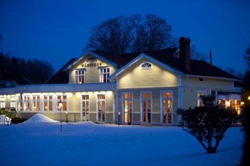 a house with lights on in the snow at night at Hestraviken Hotell & Spa in Hestra