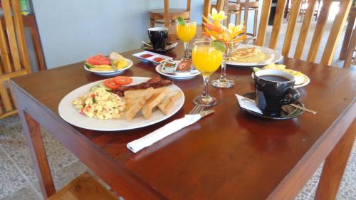 uma mesa de madeira coberta com pratos de comida e bebidas em Pemuntalan Guesthouse em Nusa Lembongan