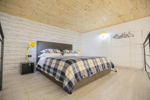 um quarto com uma cama com um cobertor xadrez em Santa Chiara Loft em Nápoles