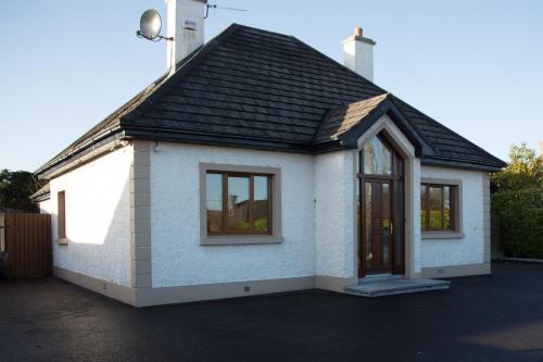 a small white house with a black roof at Lynch's Townhouse in Tullamore