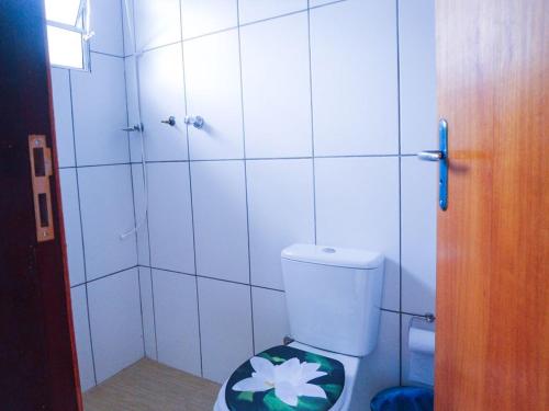 a bathroom with a toilet with a flower on it at Montanhas Bem Te Vi in Caraguatatuba
