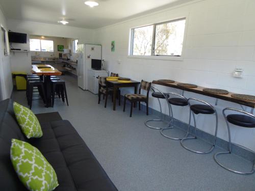 a room with a bar with stools and tables and chairs at Glenavys Waitaki River Motor Camp in Glenavy