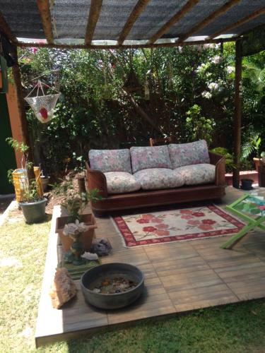 a couch sitting on a patio under a pergola at Pousada Peregrino in Barra de Jacuípe