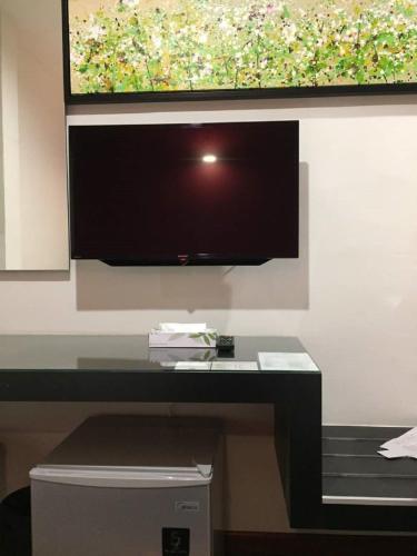 a flat screen tv hanging on a wall at Meriton Inn in Kuantan